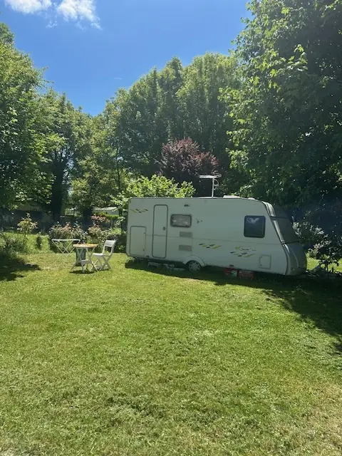 Emplacement caravane ombragé au camping Sous le Moulin, Ain